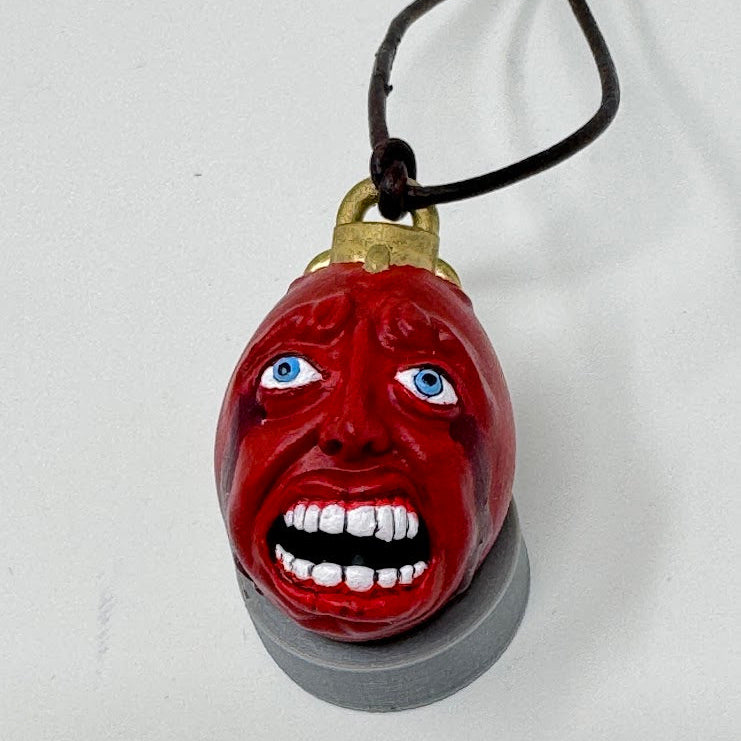 Red face pendant with blue eyes on a white background